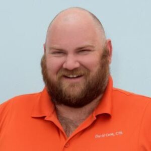 A photo of a white male with a beard smiling at the camera.